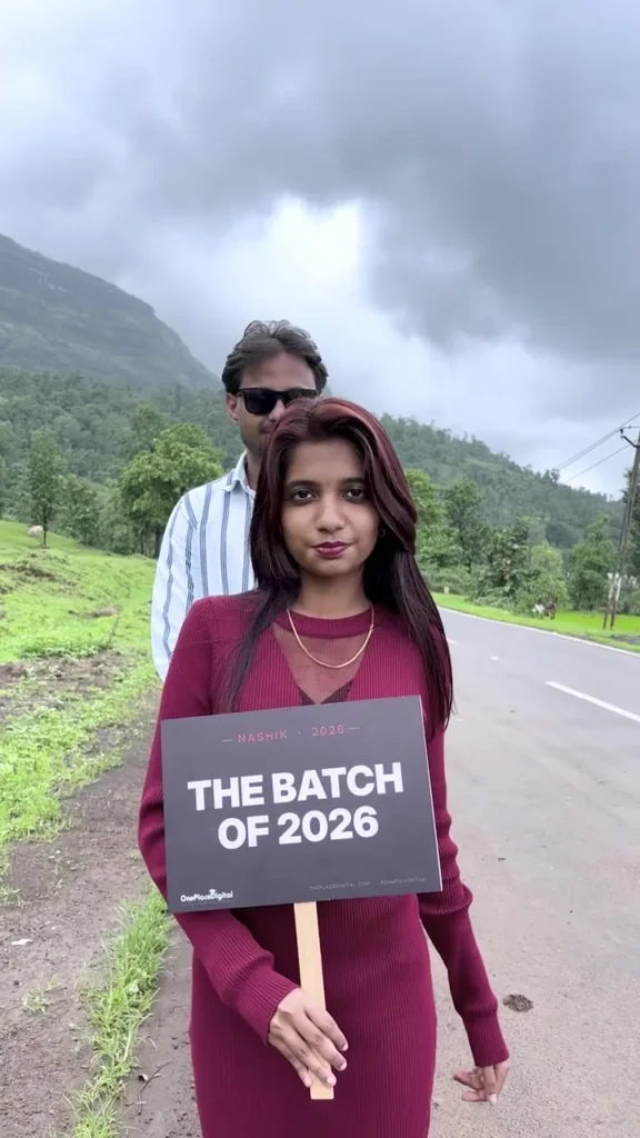 OnePlace student holding a Batch of 2026 sign on the batch trip